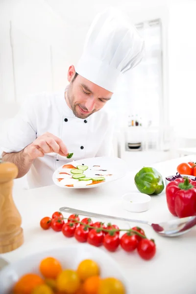 Jovem chef profissional atraente cozinhar em sua cozinha — Fotografia de Stock