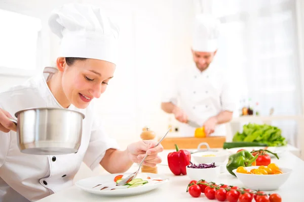 Young attractive professional chef cooking in his kitchen — Stock Photo, Image