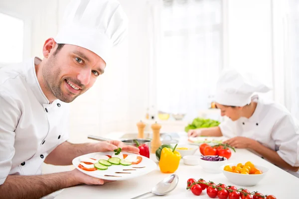 Jovem chef profissional atraente cozinhar em sua cozinha — Fotografia de Stock