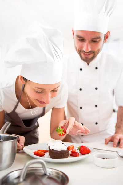 Young chef training a young attractive girl to cook — Stock Photo, Image