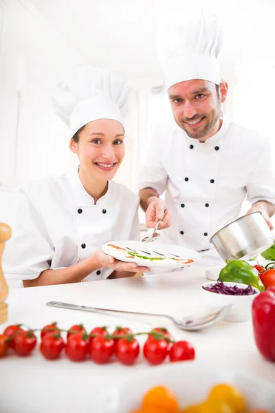 Jovens atrativos profissionais chefs cozinhar juntos — Fotografia de Stock