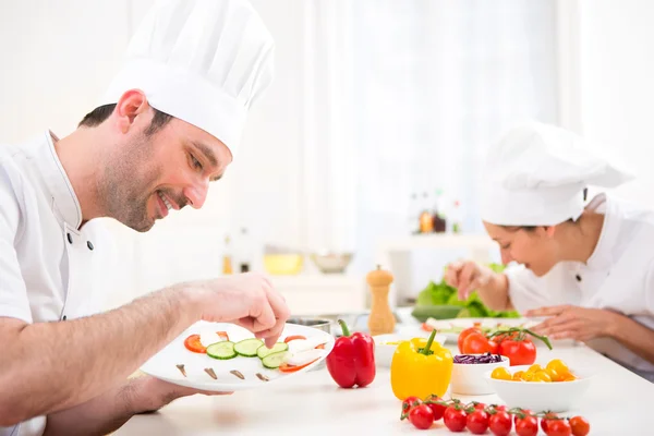 Jovem chef profissional atraente cozinhar em sua cozinha — Fotografia de Stock