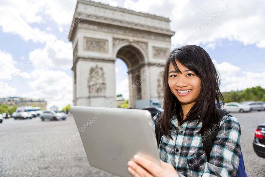 Young attractive asian tourist using tablet in Paris
