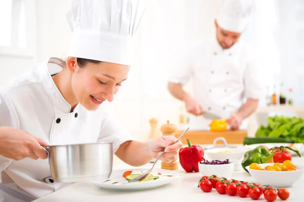 Young attractive professional chef cooking in his kitchen — Stock Photo, Image