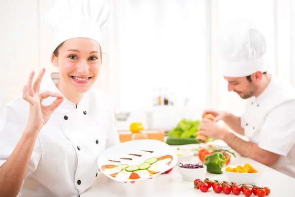 Jovem chef profissional atraente cozinhar em sua cozinha — Fotografia de Stock