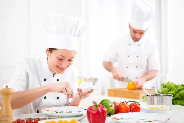 Jovem chef profissional atraente cozinhar em sua cozinha — Fotografia de Stock