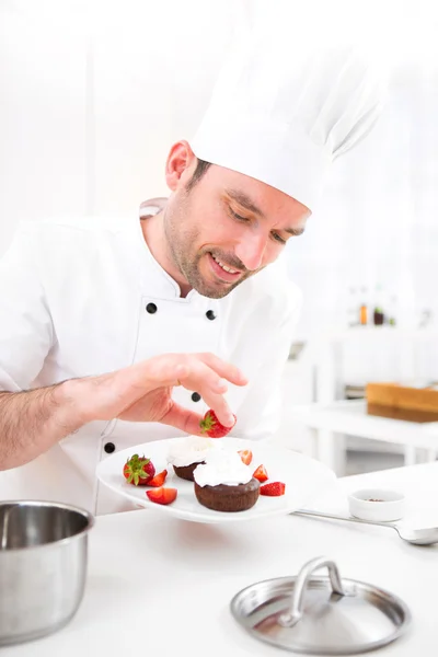 Giovane chef professionale attraente cucina nella sua cucina — Foto Stock