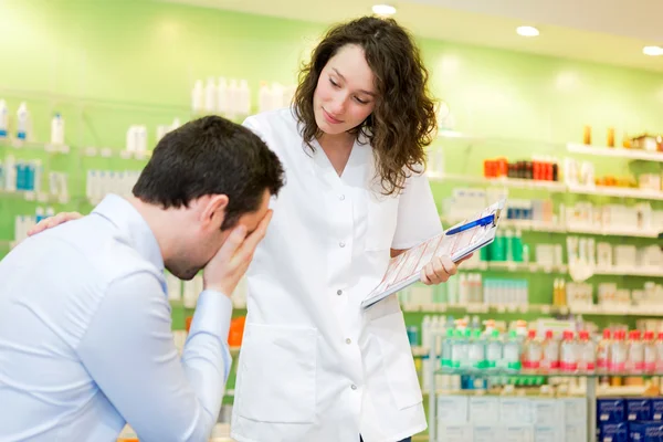 Attractive pharmacist comfort a customer suffering — Stock Photo, Image