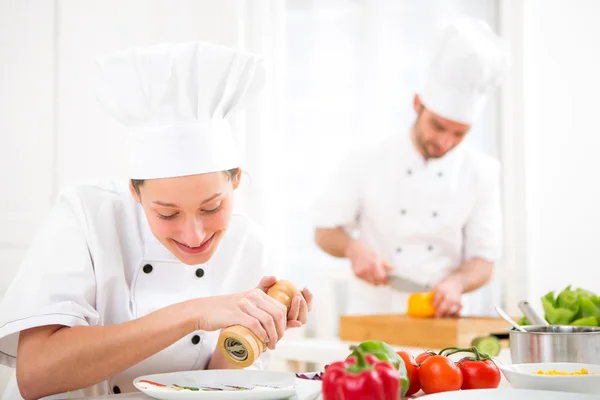 Giovane chef professionale attraente cucina nella sua cucina — Foto Stock