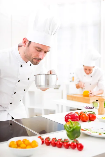 Jovem chef profissional atraente cozinhar em sua cozinha — Fotografia de Stock