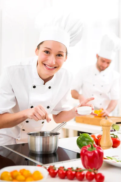 Jovem chef profissional atraente cozinhar em sua cozinha — Fotografia de Stock