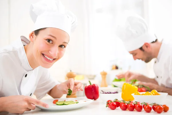 Jovem chef profissional atraente cozinhar em sua cozinha — Fotografia de Stock