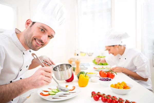 Jeune chef professionnel attrayant cuisinant dans sa cuisine — Photo