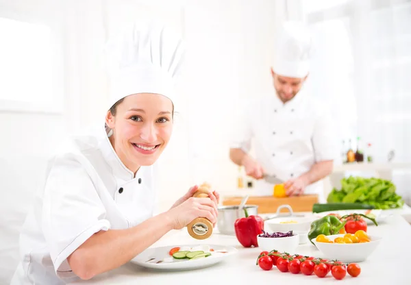 Giovane chef professionale attraente cucina nella sua cucina — Foto Stock