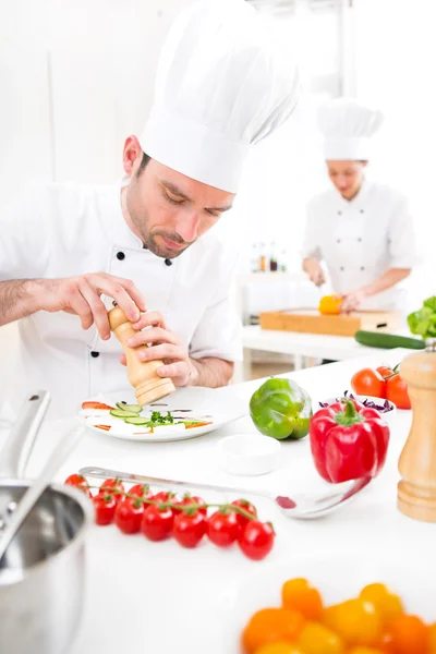 Jovem chef profissional atraente cozinhar em sua cozinha — Fotografia de Stock