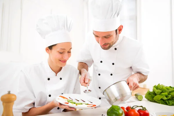 Jovens atrativos profissionais chefs cozinhar juntos — Fotografia de Stock