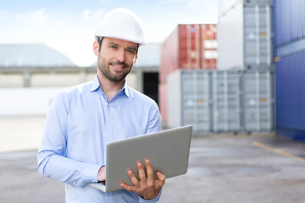 Joven ingeniero atractivo usando portátil en el muelle — Foto de Stock