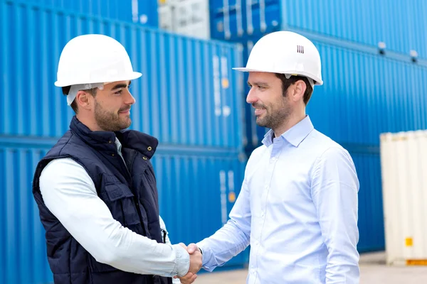 Docker and supervisor handshaking in front of containers — Stock Photo, Image