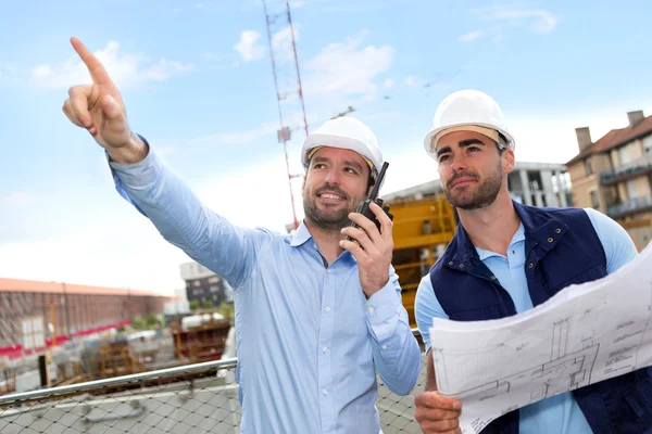 Worker and architect watching some details on a construction — Stock Photo, Image