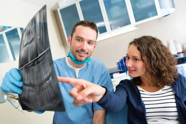 Jonge aantrekkelijke tandarts x-ray tonen aan patiënt — Stockfoto