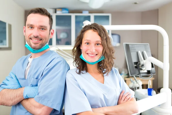 Porträt eines jungen attraktiven Zahnarztes und seiner Assistentin in seinem — Stockfoto