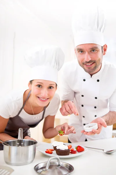 Young chef training a young attractive girl to cook — Stock Photo, Image