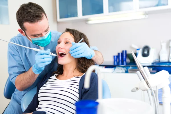 Jovem mulher atraente sendo curada por um dentista — Fotografia de Stock