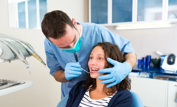 Jovem mulher atraente sendo curada por um dentista — Fotografia de Stock