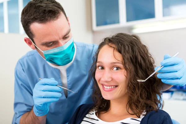 Young attractive woman being cured by a dentist — Stock Photo, Image