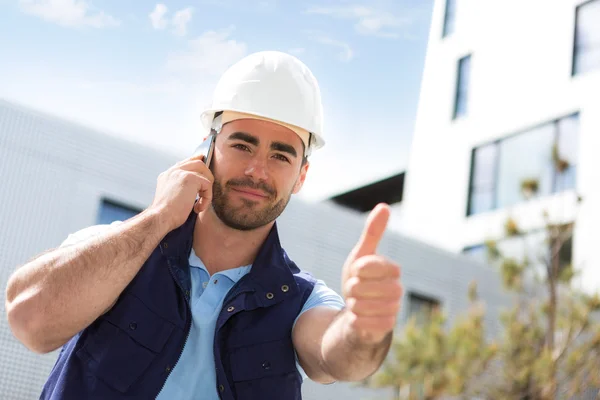 Yong attractive worker using mobile phone  on a construction sit — Stock Photo, Image