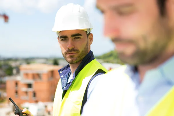 Retrato de um trabalhador atraente num canteiro de obras — Fotografia de Stock