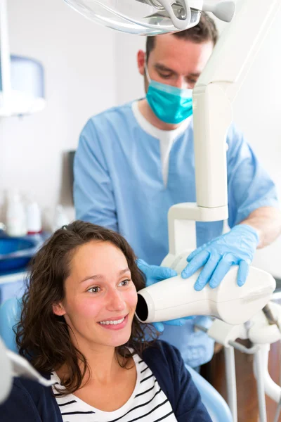 Young attractive dentist doing a radiography of woman teeth — Stock Photo, Image