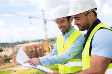 mühendis ve işçi blueprint inşaat sitesinde izliyor 