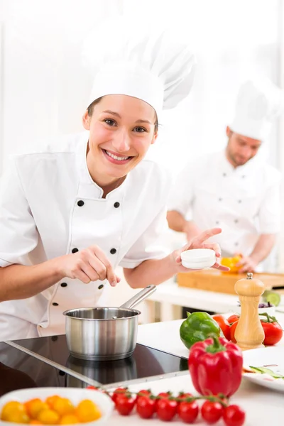 Giovane chef professionale attraente cucina nella sua cucina — Foto Stock
