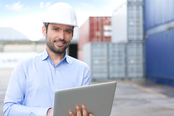 Joven ingeniero atractivo usando portátil en el muelle —  Fotos de Stock