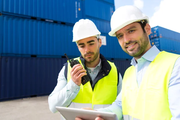 Dock worker and supervisor checking containers data on tablet — Stock Photo, Image