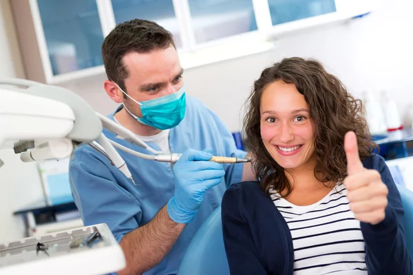 Young attractive woman being cured by a dentist — Stock Photo, Image