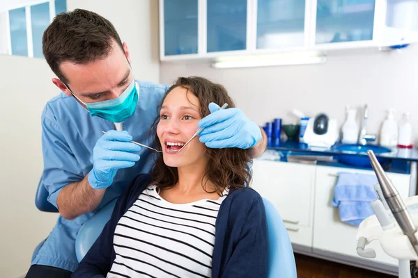 Jovem mulher atraente sendo curada por um dentista — Fotografia de Stock