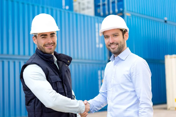 Docker and supervisor handshaking in front of containers — Stock Photo, Image