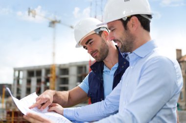 mühendis ve işçi blueprint inşaat sitesinde izliyor