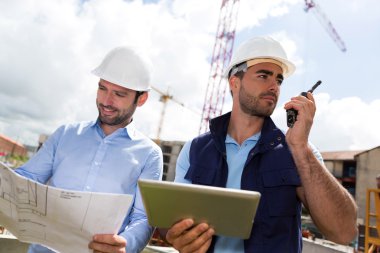 mühendis ve işçi blueprint inşaat sitesinde izliyor