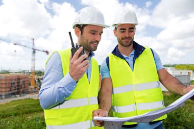 mühendis ve işçi blueprint inşaat sitesinde izliyor