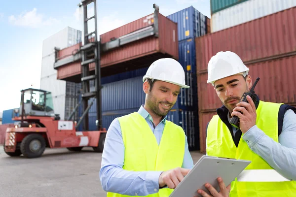 Dock worker and supervisor checking containers data — Stock Photo, Image