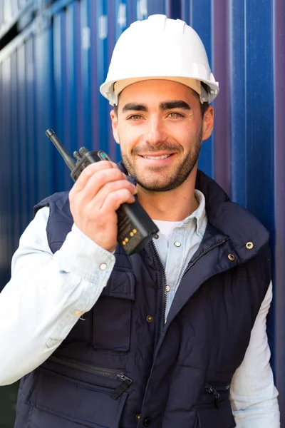 Junge attraktive Hafenarbeiter mit Talkie-Walkie bei der Arbeit — Stockfoto