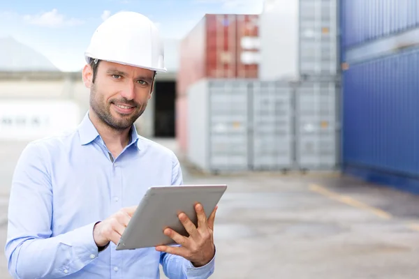 Joven ingeniero atractivo usando tableta en el muelle —  Fotos de Stock