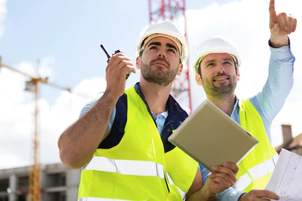 Arbetare och arkitekt tittar några detaljer på en konstruktion — Stockfoto