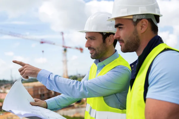 Trabalhador e arquiteto assistindo alguns detalhes sobre uma construção — Fotografia de Stock