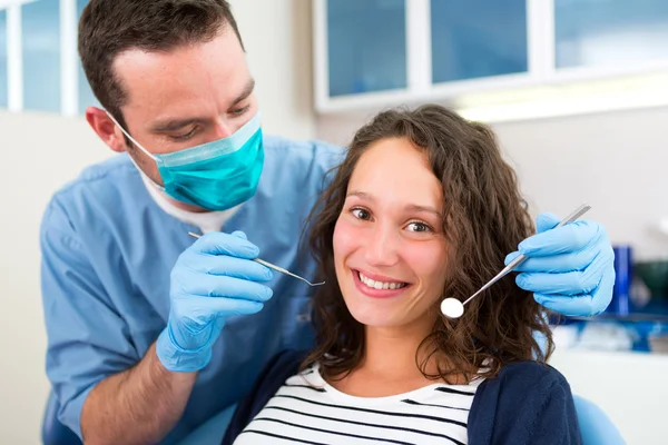 Young attractive woman being cured by a dentist — Stock Photo, Image