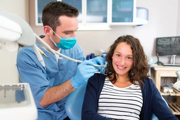 Young attractive woman being cured by a dentist — Stock Photo, Image