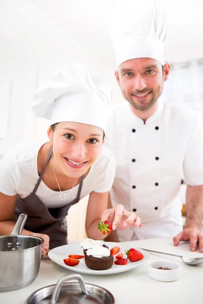 Young chef training a young attractive girl to cook — Stock Photo, Image